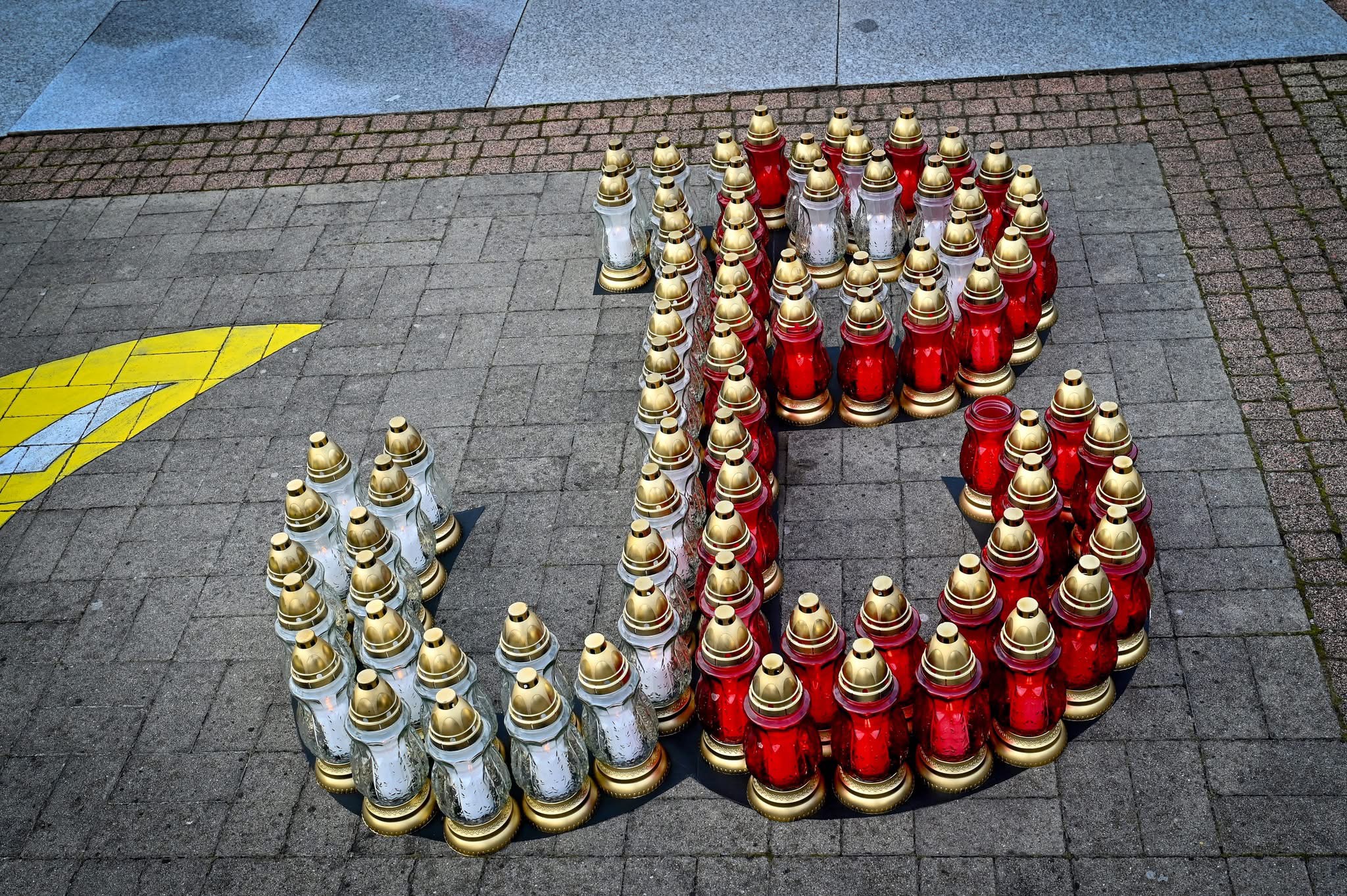 Znak Polski walczącej ułożony z biało-czerwonych zniczy